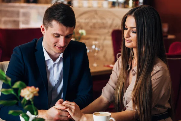 Pareja enamorada en el restaurante tomados de la mano —  Fotos de Stock