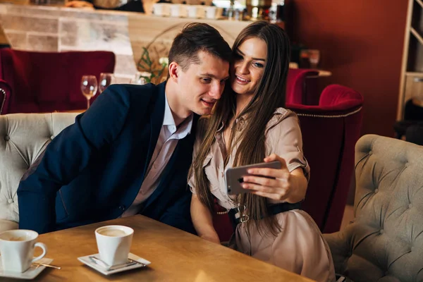 Szczęśliwa Młoda para biorąc selfie z inteligentny telefon w kawiarni — Zdjęcie stockowe