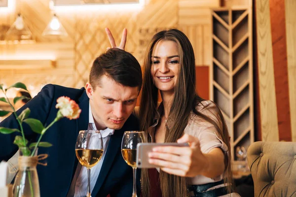 Feliz joven pareja tomando selfie con teléfono inteligente en la cafetería —  Fotos de Stock