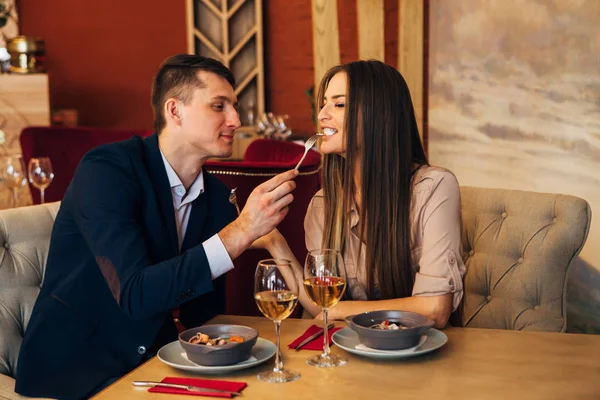 Un uomo nutre la sua donna in un ristorante — Foto Stock