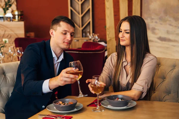 Coppia sorridente che cena e beve vino bianco all'appuntamento nel ristorante — Foto Stock