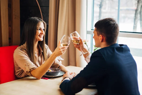 Young happy couple romantic date drink glass of white wine at restaurant, celebrating valentine day — Stock Photo, Image