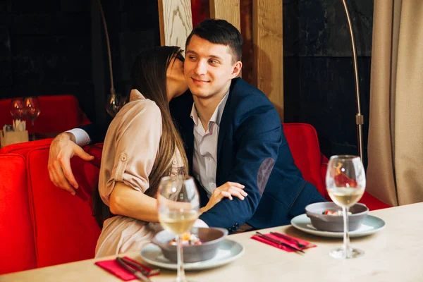 Молодая девушка в ресторане целует своего парня — стоковое фото