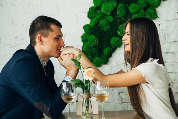 Giovane allegro uomo e donna sono incontri nel ristorante. Sono seduti a tavola e si guardano con amore . — Foto Stock