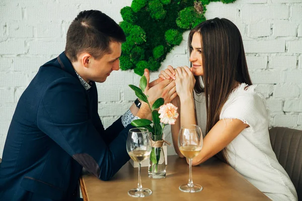 Giovane allegro uomo e donna sono incontri nel ristorante. Sono seduti a tavola e si guardano con amore . — Foto Stock