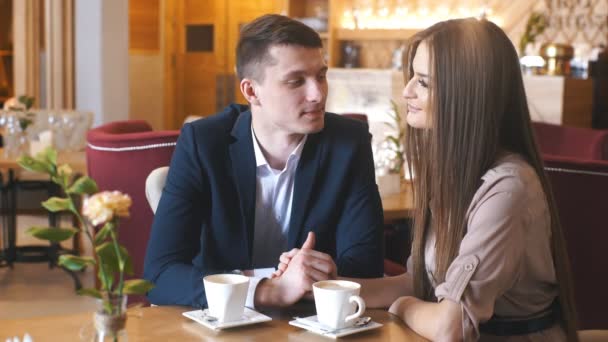 Флирт в кафе. Прекрасная любящая пара, сидящая в кафе, наслаждаясь кофе и беседой — стоковое видео