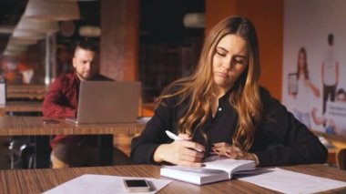 Güzel kız notları kafeteryada yapıyor