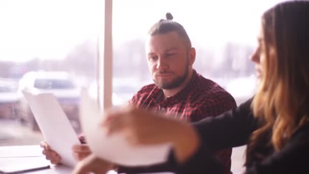 Erkek ve kadın serbest iş tartışmak ve belgeleri gözden geçirmek mutlu serbest — Stok video
