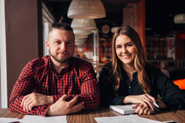 Deux heureux pigiste souriant à la caméra dans le café — Photo