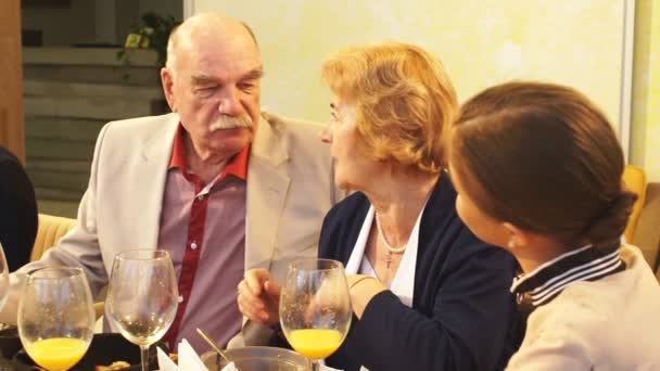 Senior man zijn vrouw kussen in overdekte café — Stockvideo