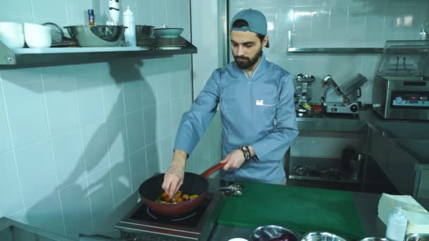 De chef-kok bak verse groenten in een pan — Stockvideo