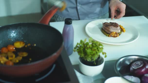 Köksmästaren sätter grönsaker på en tallrik med kött — Stockvideo