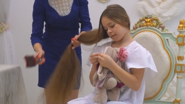 Beautiful mom and daughter are smiling while sitting on armchair at home — Stock Video