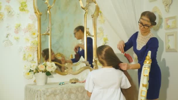 Мама расчесывает волосы своих дочерей — стоковое видео