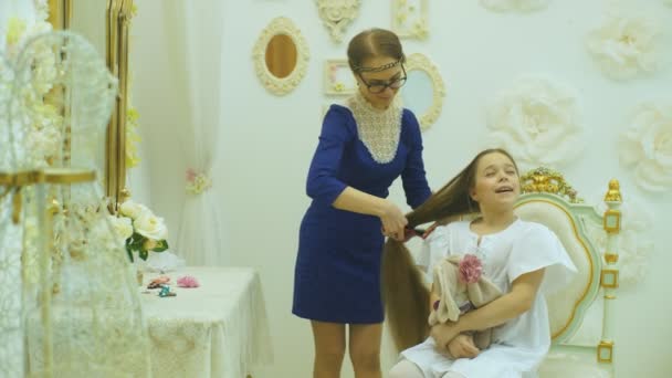 Мама расчесывает волосы своих дочерей — стоковое видео