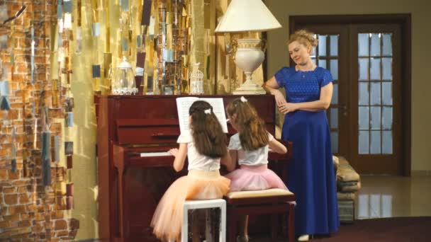 Twee mooie meisjes spelen de piano — Stockvideo