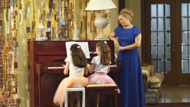 Madre e hijas aprenden a tocar el piano juntas en casa — Vídeos de Stock