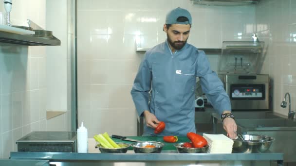 Szakács darabolt zöldségeket a konyhában — Stock videók