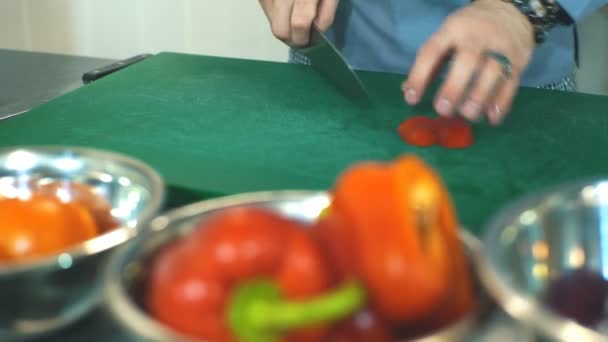 Kocken skär grönsaker i köket — Stockvideo