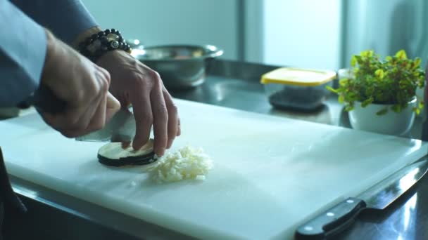 Профессиональный повар быстро режет баклажаны на доске ножом — стоковое видео