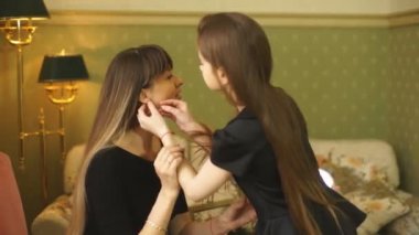 kızı anne küpelerini koymak için yardım