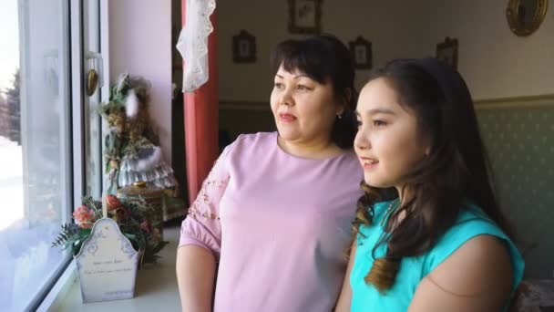 Anne ve kızı pencereden dışarı bakmak — Stok video