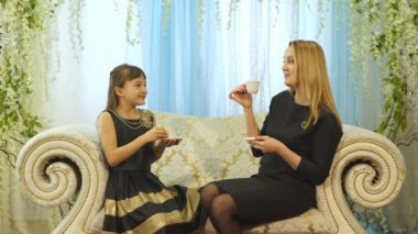 Anne ve kızı koltukta evde çay içme