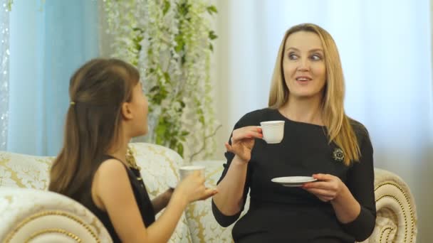 Mamma och dotter dricka te hemma i soffan — Stockvideo