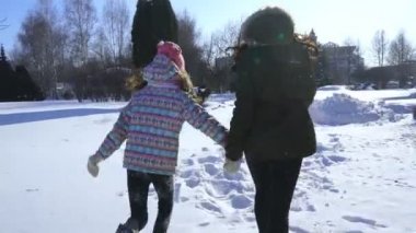 mutlu aile anne ve bebek kız kız koşmak, yürümek Kışın açık havada karda oynarken