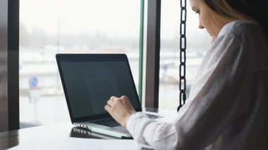 Laptop ile çalışma ve cep telefonuyla konuşurken iş kadını.