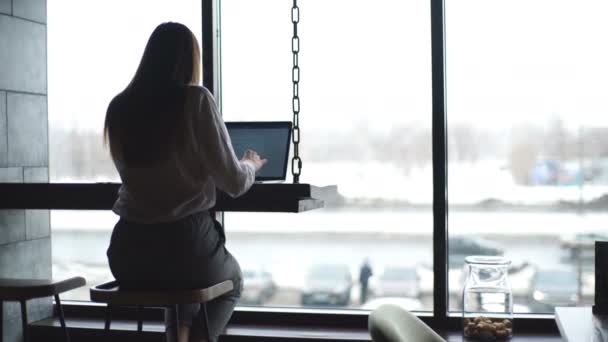 Mujer atractiva con confianza en una camisa blanca que trabaja en el café con un ordenador portátil — Vídeos de Stock