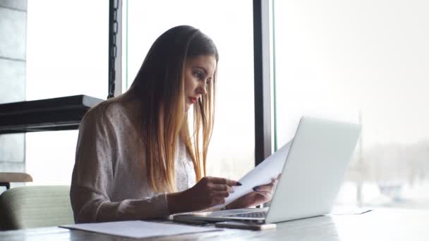 Femme d'affaires travaillant avec un ordinateur portable et vérifie les documents — Video