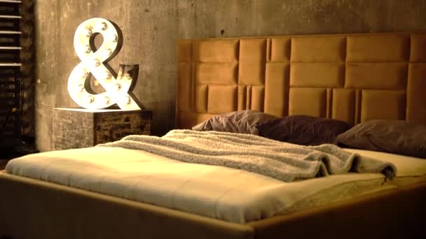 Gezellig bed met gewatteerd lederen hoofdeinde in beige en bruine kleuren en pastelkussens. — Stockvideo