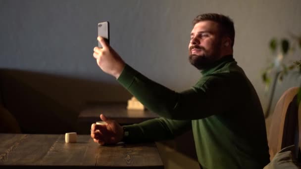 Hipster barbudo leva uma selfie em um café — Vídeo de Stock