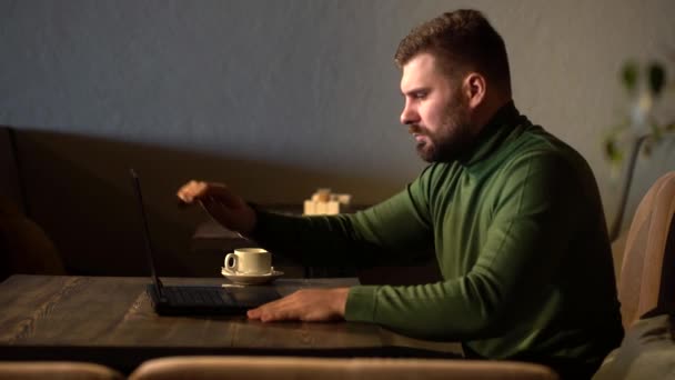 L'hipster ouvre un ordinateur portable et commence à taper les documents dans un café — Video