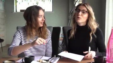İki iş kadını bir kafede sözleşme için kavga ediyor.