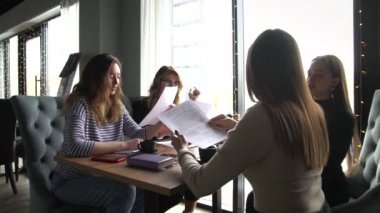 Dört genç iş kadınından oluşan bir grup, bir kafede ilginç bir fikri tartışmak için bir masada toplandı.