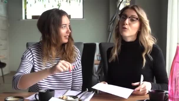 Två affärskvinnor slåss på ett café över ett kontrakt — Stockvideo