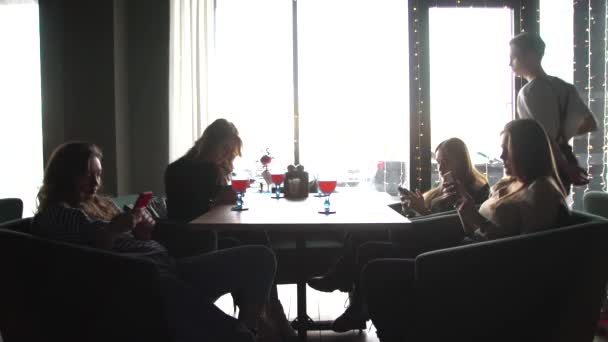 En servitör tar en drink till en grupp vänner i ett café — Stockvideo