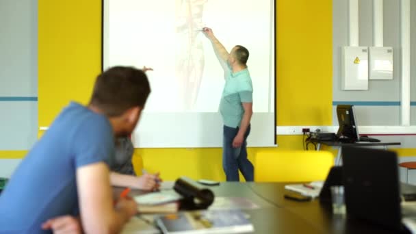 Grupo de estudiantes escuchando al profesor explicando el material en clase — Vídeo de stock