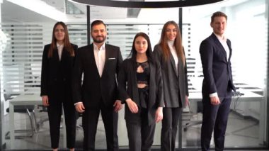 Ofiste işçilerle poz veren çeşitli profesyonel iş liderleri, ağır çekim