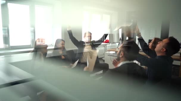 Glada arbetare kasta papper och ler i office.slow motion, skjuta genom glas — Stockvideo