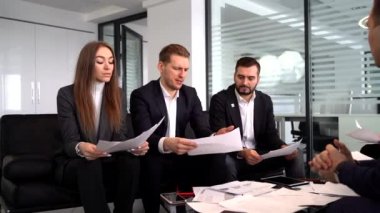 Toplantıda bir grup işadamı iş planı, sözleşmeler, belgeler hakkında konuşuyor
