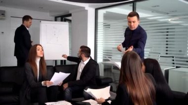 Gülümseyen milenyum erkek antrenörü veya sunucusu iş eğitimi sırasında soru sor