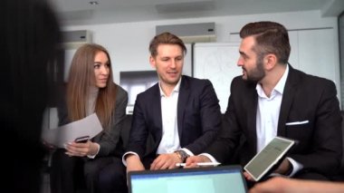 Modern iş yerinde başarılı genç mimarlar yaratıcı bir toplantı yapıyorlar. Grup lideri grafik ve grafikleri sunar
