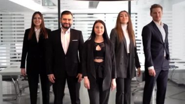 Ofiste işçilerle poz veren çeşitli profesyonel iş liderleri