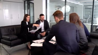 Toplantıda bir grup işadamı iş planı, sözleşmeler, belgeler hakkında konuşuyor