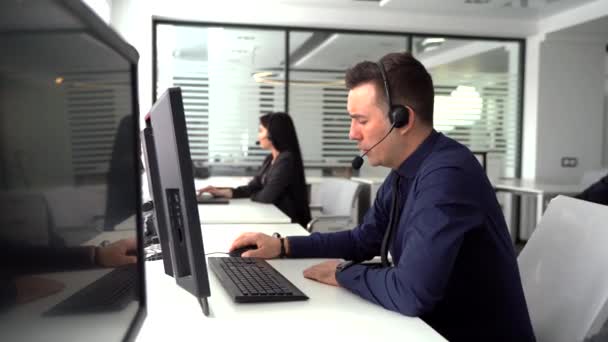 Guapo agente de servicio al cliente masculino que trabaja en la oficina del centro de llamadas como telemarketer . — Vídeo de stock