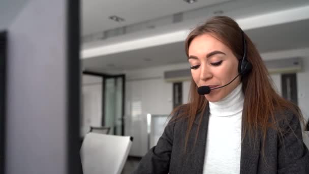 Kulaklık takıp gülümseyen kadın müşteri destek operatörü — Stok video