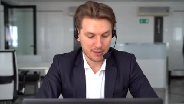 Happy customer care vertegenwoordiger man tegen kantoor achtergrond — Stockvideo